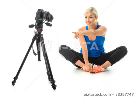 The young sporty girl with a fair hair in a black sports topic, black leggings and bright sneakers The young sporty girl with a fair hair in a black sports topic, black leggings and bright sneakers 58397747