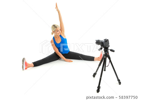 The young sporty girl with a fair hair in a black sports topic, black leggings and bright sneakers The young sporty girl with a fair hair in a black sports topic, black leggings and bright sneakers 58397750