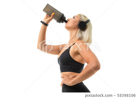 A sports girl with blonde hair and bright manicure in headphones, black sports topics and leggings A sports girl with blonde hair and bright manicure in headphones, black sports topics and leggings 58398106