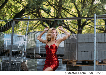 Beautiful girl with hands up in red short dress 58398545