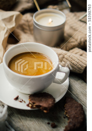 Cup of coffe with milk and chocolate cookies on warm wool blanket Cup of coffe with milk and chocolate cookies on warm wool blanket 58398763