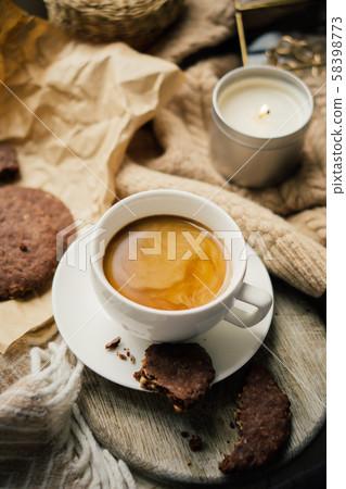 Cup of coffe with milk and chocolate cookies on warm wool blanket Cup of coffe with milk and chocolate cookies on warm wool blanket 58398773