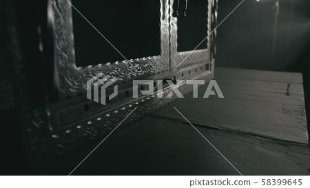 Forge workshop. Smithy manual production. A worker paints a part from a spray gun in black color 58399645