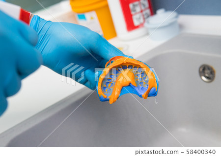 The dentist rinses the dental impression with 58400340