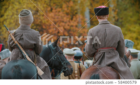 Two military men are riding horses behind the crowd soldiers Two military men are riding horses behind the crowd soldiers 58400579