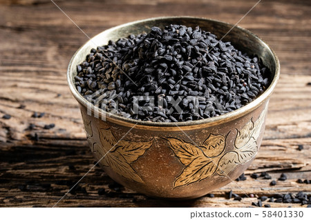 Black cumin seeds in a bowl on a table 58401330