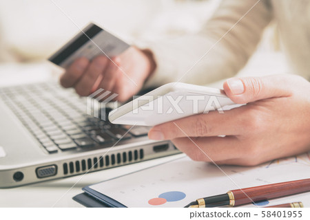 Womans hand holding credit card and smartphone Womans hand holding credit card and smartphone 58401955