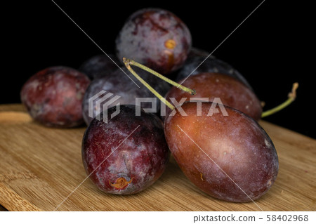 Sweet purple plum isolated on black glass 58402968