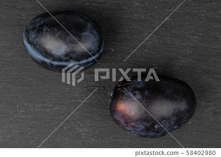 Fresh purple plum on grey stone 58402980