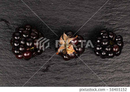 Fresh blackberry on grey stone Fresh blackberry on grey stone 58403152