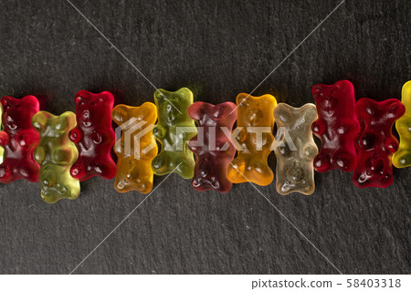 Colorful gummy bear on grey stone Colorful gummy bear on grey stone 58403318