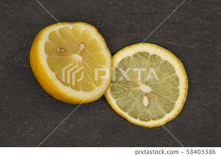 Fresh yellow lemon on grey stone Fresh yellow lemon on grey stone 58403386