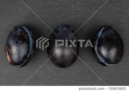 Fresh purple plum on grey stone Fresh purple plum on grey stone 58403663