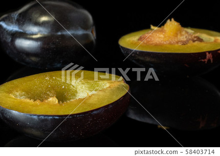 Fresh purple plum isolated on black glass 58403714