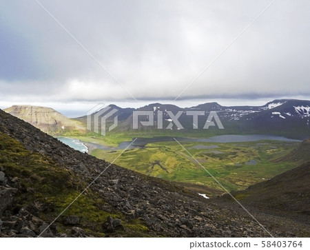 Northern summer landscape, View on beautiful snow covered cliffs and fljotsvatn lake in Fljotavik 58403764