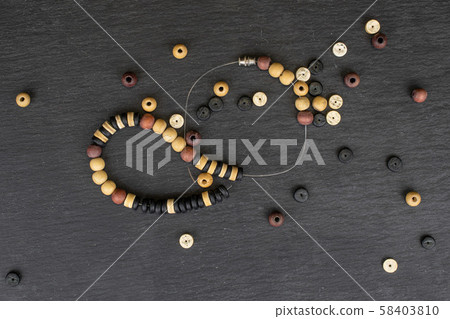 Colorful wooden bead on grey stone Colorful wooden bead on grey stone 58403810