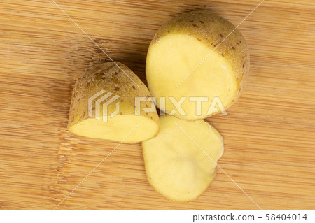 Raw brown potato on light wood Raw brown potato on light wood 58404014