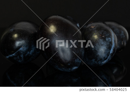 Fresh purple plum isolated on black glass Fresh purple plum isolated on black glass 58404025