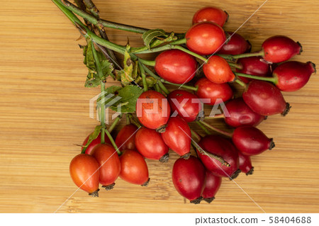 Fresh red rosehip on light wood Fresh red rosehip on light wood 58404688