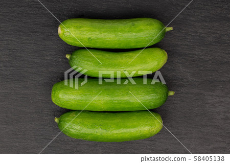 Fresh mini cucumber on grey stone Fresh mini cucumber on grey stone 58405138
