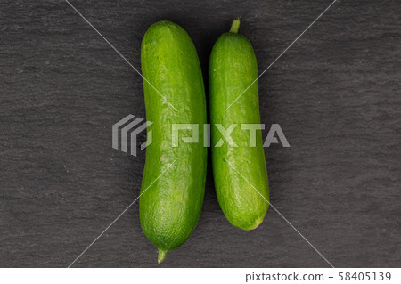 Fresh mini cucumber on grey stone 58405139
