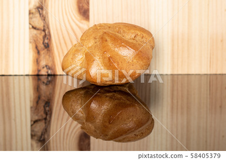 Golden baked profiterole on glass with wood Golden baked profiterole on glass with wood 58405379