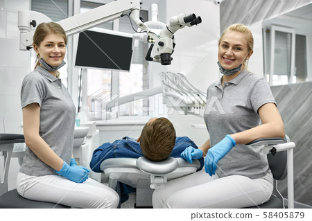 Cheerful dentists posing on camera during their work Cheerful dentists posing on camera during their work 58405879