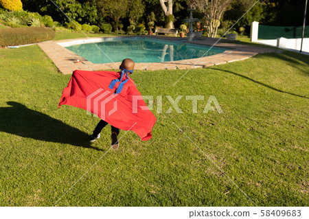 Superhero boy in garden Superhero boy in garden 58409683