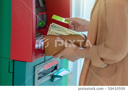 Closeup woman withdrawing the cash via ATM, business Automatic Teller Machine concept Closeup woman withdrawing the cash via ATM, business Automatic Teller Machine concept 58410509