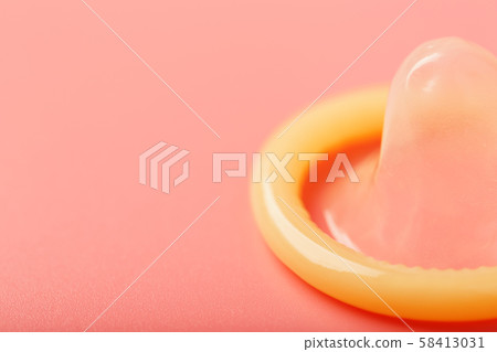 Opened condom on a pink background, close-up, top Opened condom on a pink background, close-up, top 58413031