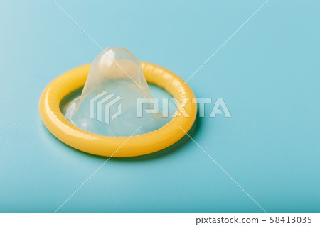 Opened condom on a blue background. Use of 58413035