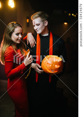 Guy in a Halloween priest costume holding a carved pumpkin in his hand. Guy in a Halloween priest costume holding a carved pumpkin in his hand. 58414979