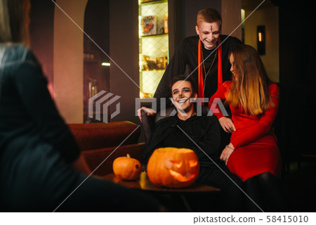 Group of four friends celebrating Halloween in a cafe Group of four friends celebrating Halloween in a cafe 58415010