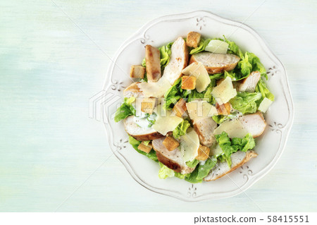 Chicken Caesar salad plate. Chicken breast, green lettuce, Parmesan cheese, and croutons, shot from Chicken Caesar salad plate. Chicken breast, green lettuce, Parmesan cheese, and croutons, shot from 58415551