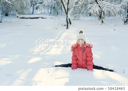 Girl does gymnastics in the winter in the park 58418463