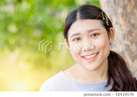 Innocent beautiful cute girl teeth smiling outdoor closeup green nature Innocent beautiful cute girl teeth smiling outdoor closeup green nature 58419570