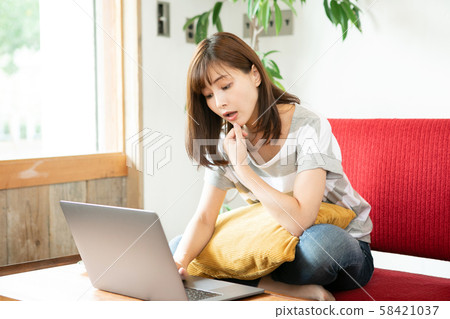 在房間裡玩個人電腦的女人 58421037