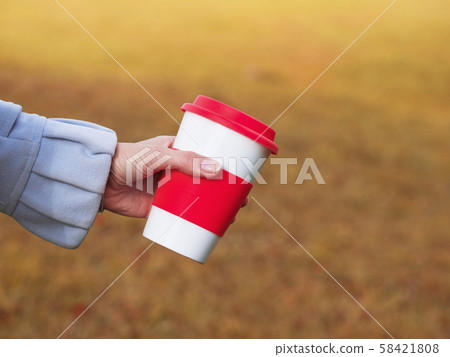 Reusable coffee cup in the hands on the nature 58421808