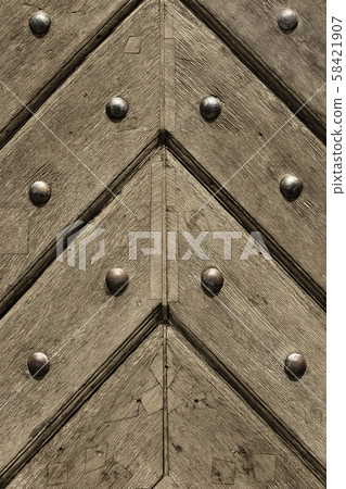 Fragment of old wooden doors with metal rivets 58421907