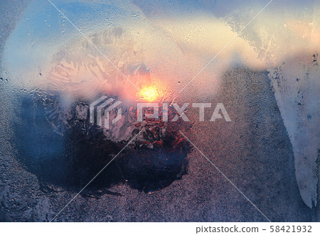 Ice pattern and water drops on glass on a sunny Ice pattern and water drops on glass on a sunny 58421932