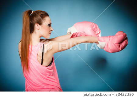 Female boxer wearing big fun pink gloves playing Female boxer wearing big fun pink gloves playing 58422380
