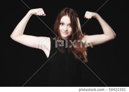 teen girl showing her muscles on black 58422381