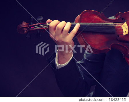 Man man dressed elegantly playing violin 58422435