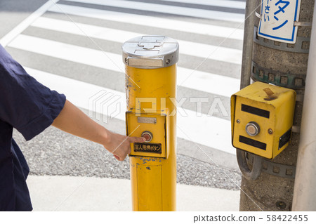 Woman pushing pushbutton for blind 58422455