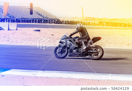 motorcycle racer rides on a sports track 58424129