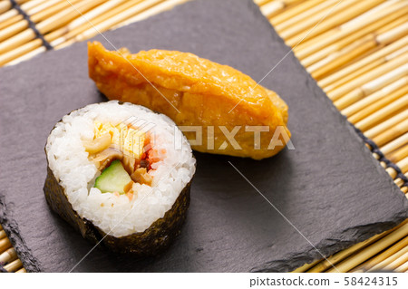 Maki Sushi and Inari Sushi. (On slate plate) Maki Sushi and Inari Sushi. (On slate plate) 58424315