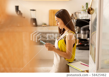Busy businesswoman reading e-mails on smartphone Busy businesswoman reading e-mails on smartphone 58425462