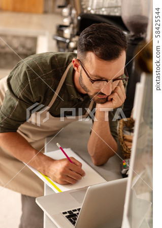 Owner of coffee shop writing points for future development Owner of coffee shop writing points for future development 58425544