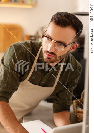 Dark-eyed owner of coffee shop feeling thoughtful 58425547