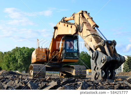 Excavator with hydraulic shears breaks asphalt on a construction site 58425777